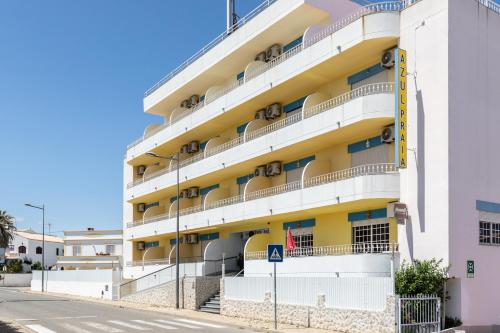 an apartment building with balconies on a street at Hotel Azul Praia in Altura