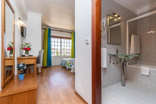Camera dotata di bagno con lavandino e scrivania. di Hotel Azul Praia ad Altura