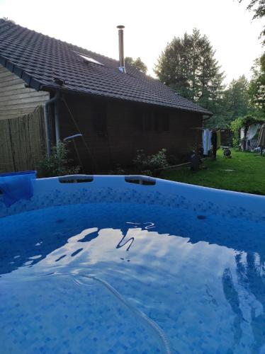 a large blue swimming pool with a house in the background at leschambresdanne in Chameyrat