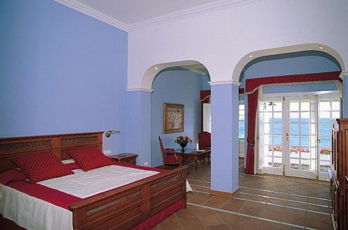 a bedroom with a large bed and a balcony at Hotel Casa Del Embajador in Playa Blanca