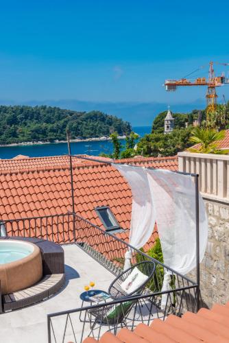 a patio with a hot tub and chairs on a roof at Villa Lizza in Cavtat