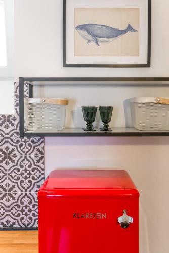 a red ottoman in front of a shelf with two glasses at Villa Lizza in Cavtat