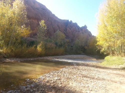 a river with a mountain in the background at Auberge Restaurant Zahra in Boumalne