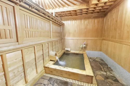 高野山 宿坊 大明王院 -Koyasan Shukubo Daimyououin- في كوياسان: حوض جاكوزي في غرفة مع جدران خشبية
