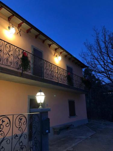 a building with a balcony with lights on it at AFFITTACAMERE POGGIGRILLI in Pievepelago