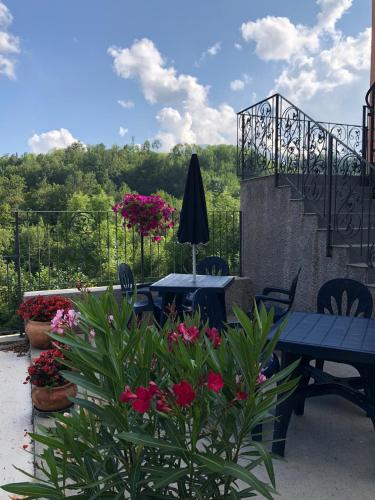 a patio with a table and chairs and flowers at AFFITTACAMERE POGGIGRILLI in Pievepelago