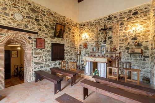 a church with wooden benches in a stone wall at Tenuta Ciminata Greco in Rossano