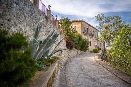 a cobblestone street next to a stone wall at Tenuta Ciminata Greco in Rossano