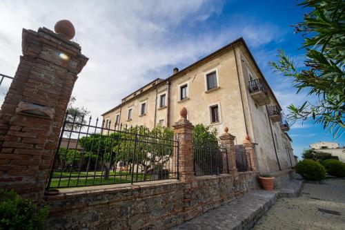 a building with a gate and a brick pillar at Tenuta Ciminata Greco in Rossano