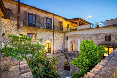 an old stone building with a courtyard with plants at Tenuta Ciminata Greco in Rossano