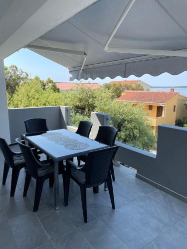 a table and chairs on a balcony with a view at Apartments Bakula in Mandre