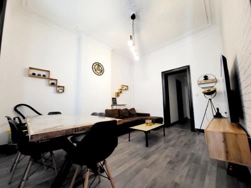 een kamer met een tafel en stoelen en een bank bij Private Room in center of Charleroi in Charleroi