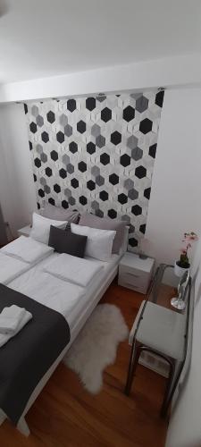 een slaapkamer met een bed en een tafel en een muur bij Apartman Djoana - dvosoban apartman u blizini Akva Parka Vrnjačke Terme in Vrnjačka Banja