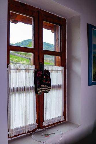 a window with white curtains in a room at Apartment ''Planinsko selo'' in Zaovine