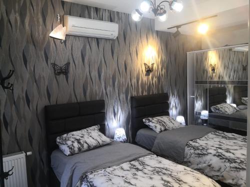 een slaapkamer met 2 bedden en een muur met vlinders bij My G yoo Apartment #2 in Istanbul