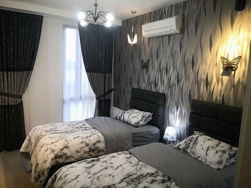 two beds in a bedroom with butterflies on the wall at My G yoo Apartment #2 in Istanbul