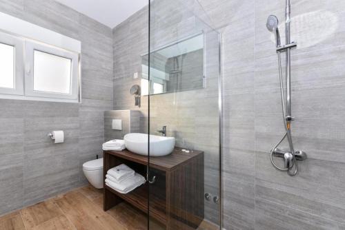 a bathroom with a sink and a shower at Luxury Villa HARBOR in Bibinje