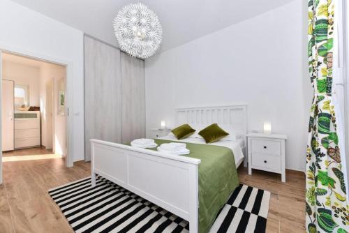 a white bedroom with a bed and a chandelier at Luxury Villa HARBOR in Bibinje