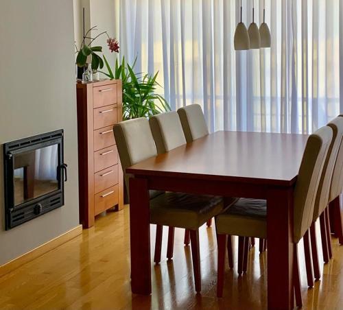 a dining room table with chairs and a television at Yellow Five Apartment in Ponta Delgada