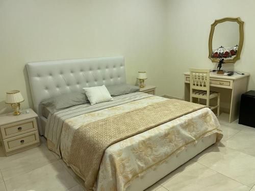 1 dormitorio con cama, escritorio y espejo en Nicole House, en Reggio Calabria
