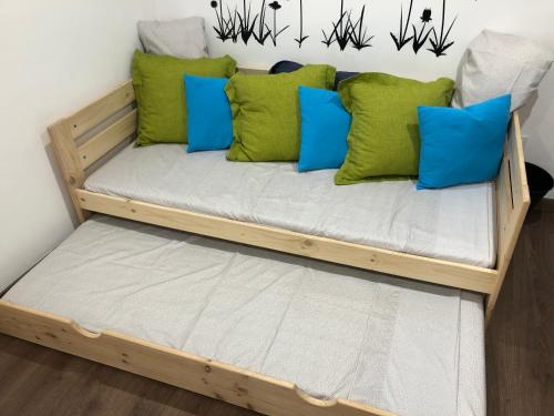 Montederramo的住宿－Apartamento rural con increíbles vistas，一张带绿色和蓝色枕头的木制蒲团床
