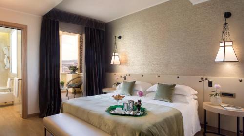 a bedroom with a large bed with a tray on it at Starhotels Metropole in Rome