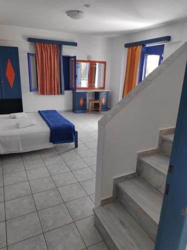 a bedroom with a bed and stairs in a room at Leonidas Studios & Apartments in Georgioupolis