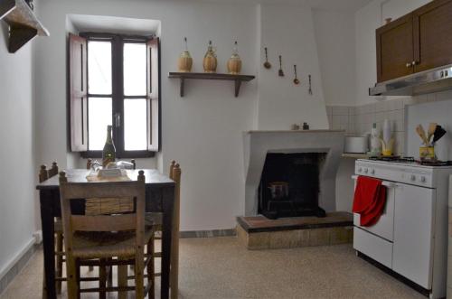 una cucina con tavolo, piano cottura e camino di Casa Claudia a Norma