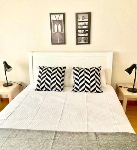 a white bed with two pillows and two lamps at Yellow Five Apartment in Ponta Delgada