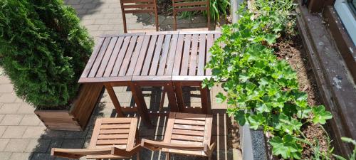 an overhead view of a wooden picnic table and chairs at Ferienwohnung Halle/Lettin in Halle an der Saale