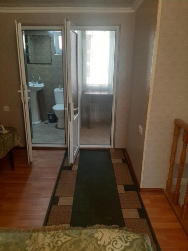 a bathroom with a door open to a bathroom with a toilet at NarVar Hotel in Goris