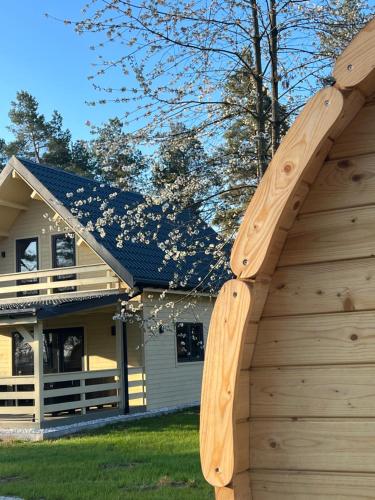 a house with a wooden building with a wooden fence at Aparthouse Siemiany in Siemiany