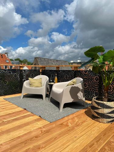 a patio with two chairs and a table on a deck at Kalckmate in Goes