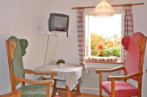 a living room with a table and chairs and a tv at Bräugasthof Hallstatt in Hallstatt