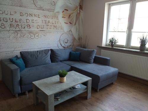 sala de estar con sofá azul y mesa en Ferienwohnung Radebeul Self Check-in en Radebeul