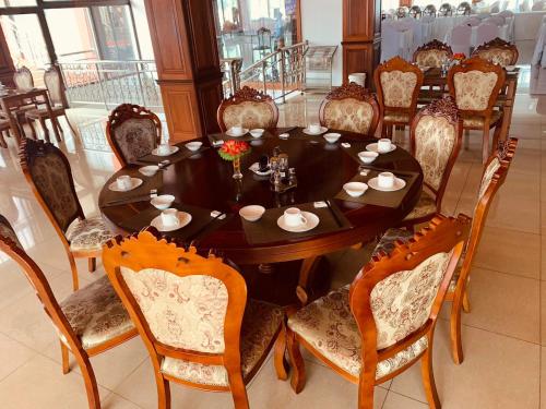 a dining room with a wooden table and chairs at Asia & Africa Hôtel in Antananarivo