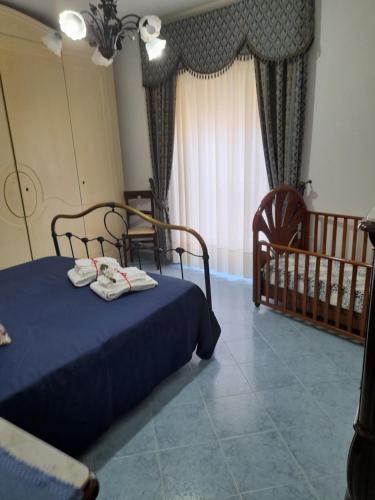 1 dormitorio con 1 cama azul y 1 cuna en Casa Holiday, en Caccamo