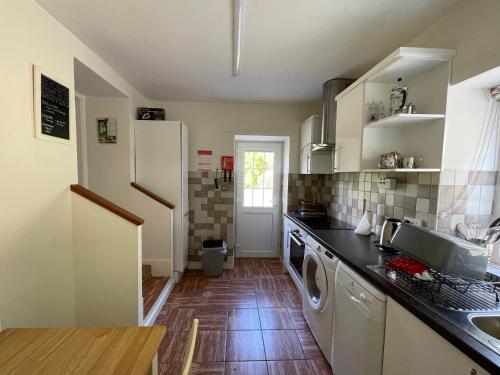 een keuken met een wastafel, een wasmachine en een droger bij Cosy 2 Bedroom Cottage in Betws y Coed, Snowdonia in Betws-y-coed