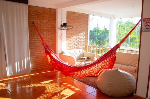 a red hammock in a living room at Pousada Pomar De Manguinhos in Manguinhos