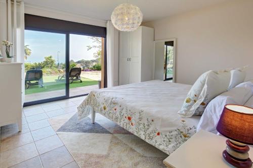 a bedroom with a bed and a large window at VILLA LA CALA with swimming pool & sea view, 10 min walk from the sea in Blanes