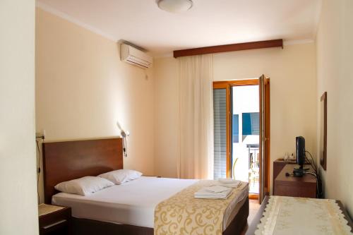 a hotel room with two beds and a balcony at Apartments MUN Petrovac in Petrovac na Moru