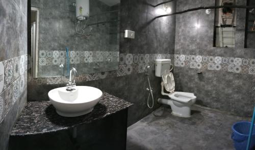 Monkey Mind Hostel في مادغاون: حمام مع حوض ومرحاض
