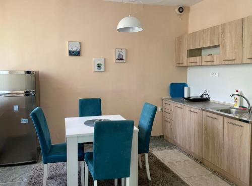 a kitchen with a table and chairs and a refrigerator at City Place Apartments in Kumanovo