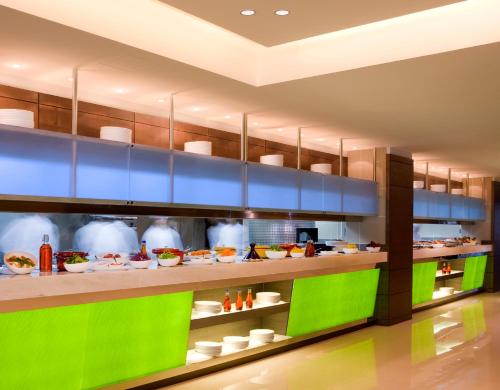 a kitchen with green and blue shelves with food at Traders Hotel, Abu Dhabi in Abu Dhabi