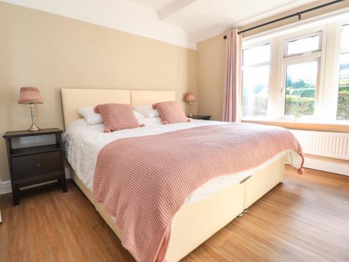 Un dormitorio con una cama grande y una ventana en Farnhill View en Keighley