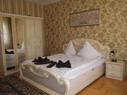 una camera da letto con un letto bianco con scarpe nere sopra di Ametist a Mukačevo