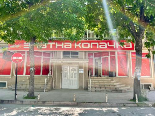 a konung building with a red and white sign on it at City Place Apartments in Kumanovo