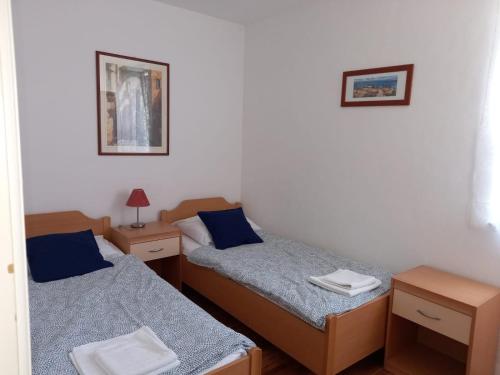 Habitación con 2 camas y 2 mesitas de noche en Apartman BoloB en Baška