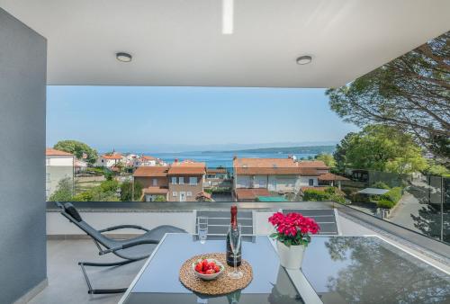 a view from the balcony of a house with a table and flowers at Modern Apartments Elle Malinska in Vantačići
