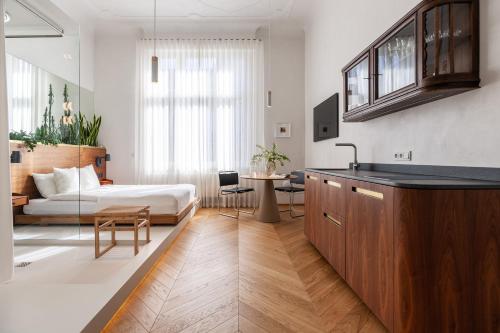1 dormitorio con 1 cama y cocina con mesa en Wyspa 12, en Poznan
